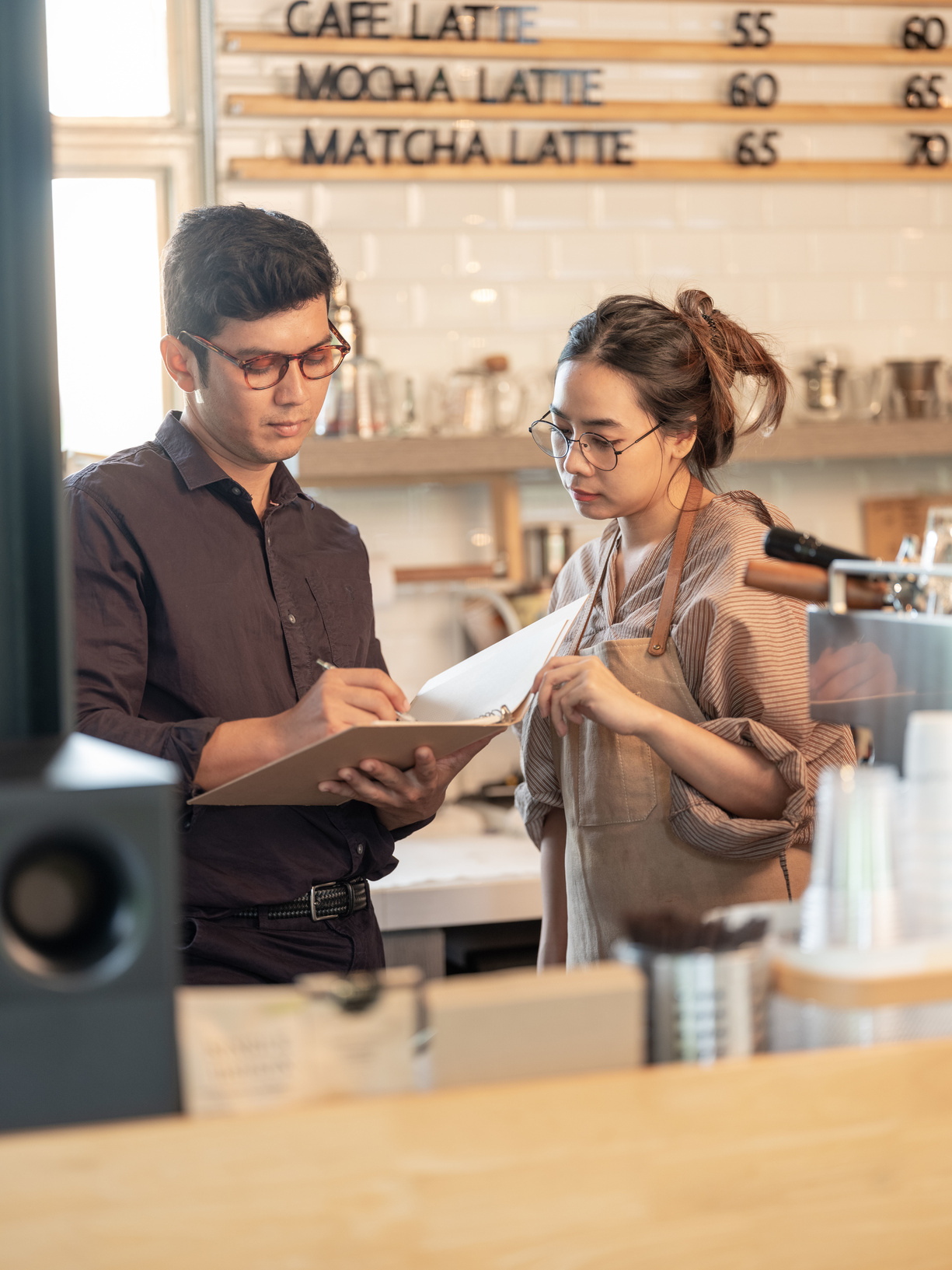 Chef d'entreprise consultant des documents administratifs avec son employée